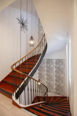 a spiral staircase with a pendant light in a room at O Carré Croisette Cannes in Cannes