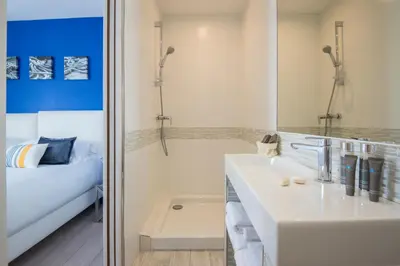 a white bathroom with a sink and a shower at O Carré Croisette Cannes in Cannes