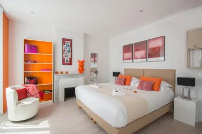 a bedroom with a large bed and a chair at O Carré Croisette Cannes in Cannes
