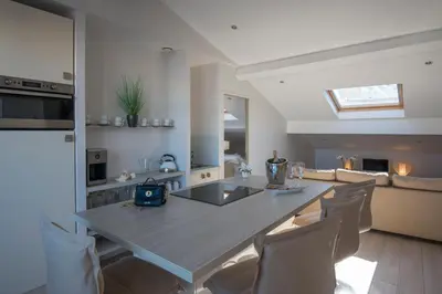 a kitchen and living room with a table and chairs at O Carré Croisette Cannes in Cannes