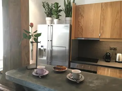 a kitchen with a table with two cups and a refrigerator at Cocoon in Cannes ***** in Cannes
