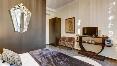 a bedroom with a bed and a television and chairs at Cocoon in Cannes ***** in Cannes