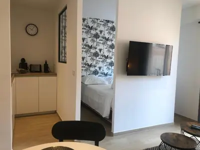a room with a bed and a tv on a wall at C001-Beau studio neuf situé au centre in Cannes
