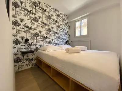 a bedroom with a large bed with a black and white wallpaper at C001-Beau studio neuf situé au centre in Cannes