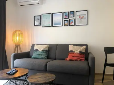 a living room with a couch and two tables at C001-Beau studio neuf situé au centre in Cannes