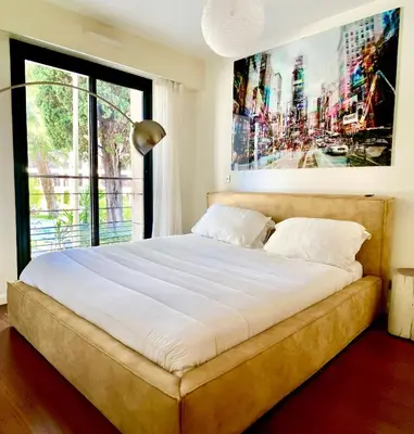 a large bed in a bedroom with a large window at Carlton Riviera in Cannes