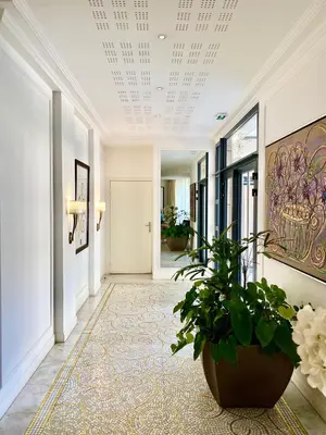 a hallway with a potted plant on the floor at Carlton Riviera in Cannes