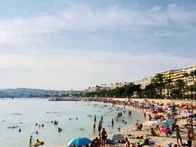 a group of people on a beach in the water at Carlton Riviera in Cannes