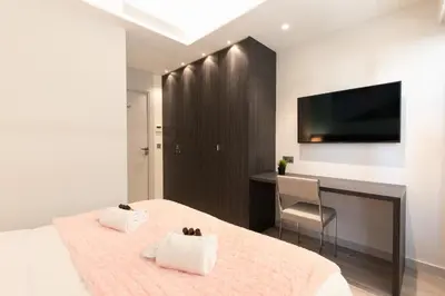 a bedroom with a bed with a desk and a television at Blue Dreams YourHostHelper in Cannes