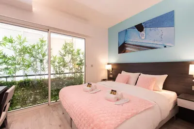 a bedroom with two beds and a large window at Blue Dreams YourHostHelper in Cannes