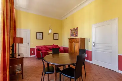 a dining room with a table and a red couch at Cannes-Hyper-Centre in Cannes