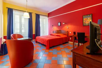 a hotel room with a red bed and chairs at Cannes-Hyper-Centre in Cannes