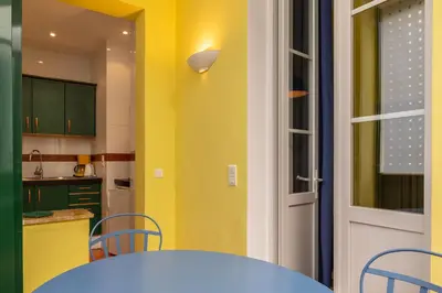 a kitchen with a table and a yellow wall at Cannes-Hyper-Centre in Cannes