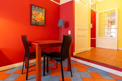 a dining room with red walls and a wooden table and chairs at Cannes-Hyper-Centre in Cannes