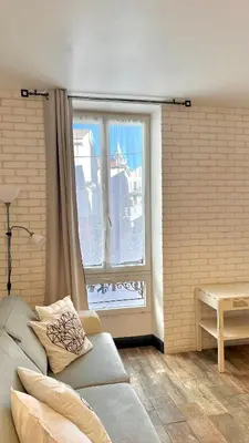 a living room with a couch and a window at Monroe's studio at the heart of Cannes and beaches in Cannes