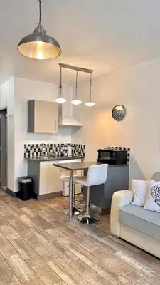 a kitchen and living room with a table and a couch at Monroe's studio at the heart of Cannes and beaches in Cannes
