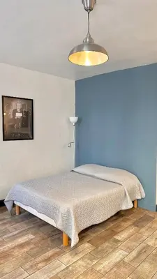 a bed in a bedroom with a blue wall at Monroe's studio at the heart of Cannes and beaches in Cannes