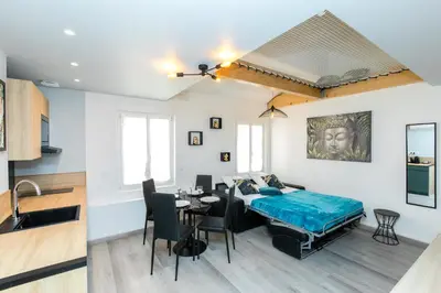 a bedroom with a bed and a dining room with a table at Duplex : Plage 300m, Clim, Netflix in Cannes