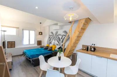 a room with a bed and a table and chairs at Duplex : Plage 300m, Clim, Netflix in Cannes