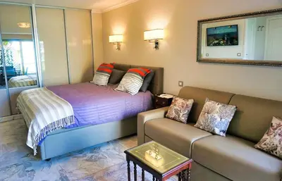 a living room with a bed and a couch at Studio Cannes center next to Croisette and rue d'Antibes in Cannes