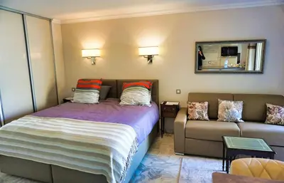 a bedroom with a bed and a couch at Studio Cannes center next to Croisette and rue d'Antibes in Cannes