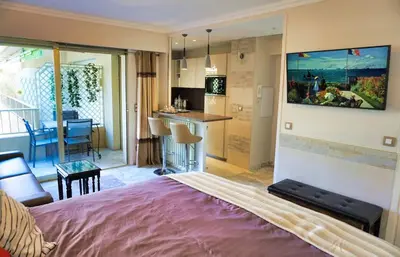 a hotel room with a bed and a kitchen and a living room at Studio Cannes center next to Croisette and rue d'Antibes in Cannes