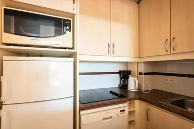 a kitchen with a white refrigerator and a microwave at Résidence Cannes Villa Francia - maeva Home - Appartement 3 Pièces 6 Personnes - Confort MAE-6059 in Cannes