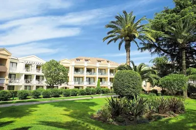 a large building with palm trees and a lawn at Résidence Cannes Villa Francia - maeva Home - Appartement 2 Pièces 4 Personnes - Budget MAE-6120 in Cannes