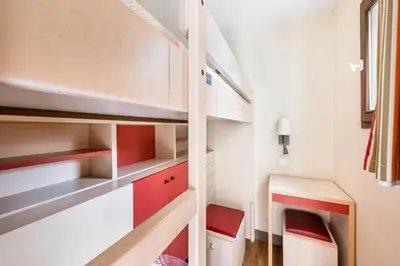 a small room with white cabinets and red accents at Résidence Cannes Villa Francia - maeva Home - Appartement 2 Pièces 6 Personnes - Budget MAE-6123 in Cannes
