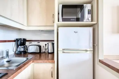 a kitchen with a white refrigerator and a microwave at Résidence Cannes Villa Francia - maeva Home - Appartement 2 Pièces 6 Personnes - Sélection MAE-6133 in Cannes