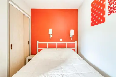 a bedroom with a bed and a red wall at Résidence Cannes Villa Francia - maeva Home - Appartement 2 Pièces 6 Personnes - Sélection MAE-6133 in Cannes