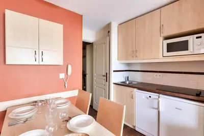 a kitchen with a table with chairs and a microwave at Résidence Cannes Villa Francia - maeva Home - Studio 4 personnes - Sélection MAE-6353 in Cannes