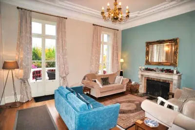 a living room with a blue couch and a fireplace at Ref ROSE - Palmes d'Or Properties in Cannes