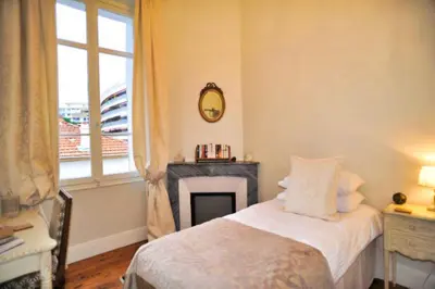 a bedroom with a bed with a fireplace and a window at Ref ROSE - Palmes d'Or Properties in Cannes