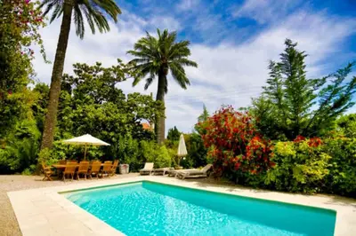 a swimming pool in a yard with chairs and trees at Ref ROSE - Palmes d'Or Properties in Cannes
