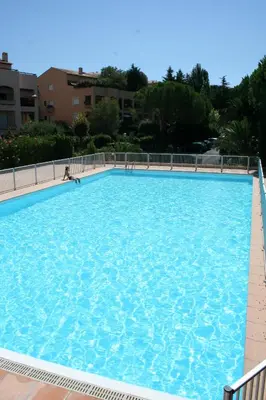 a large blue swimming pool with a person in it at Appartement de charme wi-fi ,clim, garage jardin privés, piscine environnement arboré in Cannes