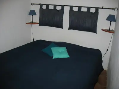 a bedroom with a green pillow on a bed at Appartement de charme wi-fi ,clim, garage jardin privés, piscine environnement arboré in Cannes