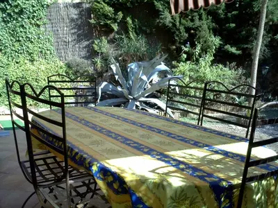 a table with a yellow and blue table cloth on it at Appartement de charme wi-fi ,clim, garage jardin privés, piscine environnement arboré in Cannes