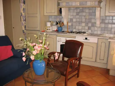 a kitchen with a glass table with a vase of flowers at Appartement de charme wi-fi ,clim, garage jardin privés, piscine environnement arboré in Cannes