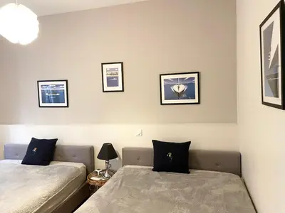 a bedroom with two beds and pictures on the wall at Cannes Old Port, SEAFRONT & SEAVIEWS new reversible air conditioning in Cannes