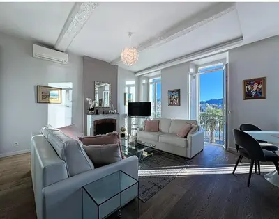 a living room with a couch and a tv and a table at Cannes Old Port, SEAFRONT & SEAVIEWS new reversible air conditioning in Cannes