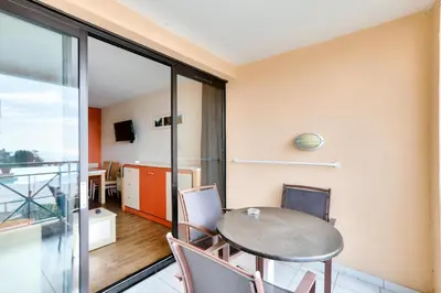 a table and chairs in a room with a balcony at Résidence Cannes Villa Francia - maeva Home - Appartement 2 pièces 4 personnes - Sélection MAE-6529 in Cannes