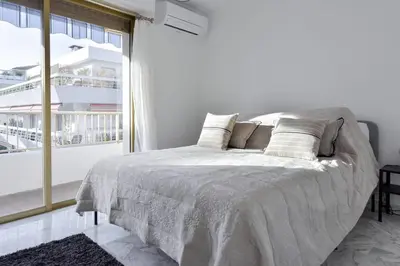 a white bedroom with a bed and a large window at Cannes Palm Beach district 2 min to the beaches in Cannes