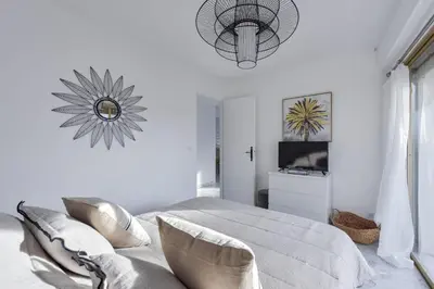a white bedroom with a bed and a mirror at Cannes Palm Beach district 2 min to the beaches in Cannes