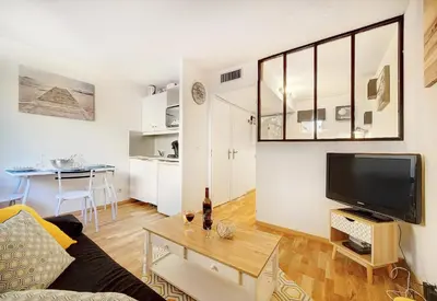 a living room with a couch and a tv and a table at Le Dol - 150m plages - Suquet - Verrière Côte d'azur in Cannes