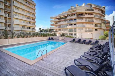 a swimming pool with chairs next to a building at Le Dol - 150m plages - Suquet - Verrière Côte d'azur in Cannes