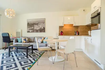a kitchen and a living room with a table and chairs at Parc Eugenie by Welcome to Cannes in Cannes