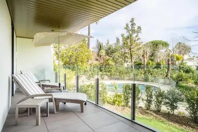 a balcony with a view of a pool and two chairs and an umbrella at Parc Eugenie by Welcome to Cannes in Cannes