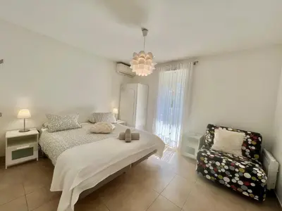 a bedroom with a bed and a chair at Parc Eugenie by Welcome to Cannes in Cannes