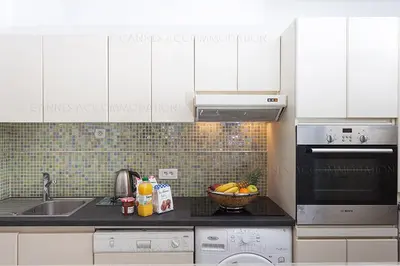 a kitchen with white cabinets and a bowl of fruit on the counter at gray 3a2 in Cannes